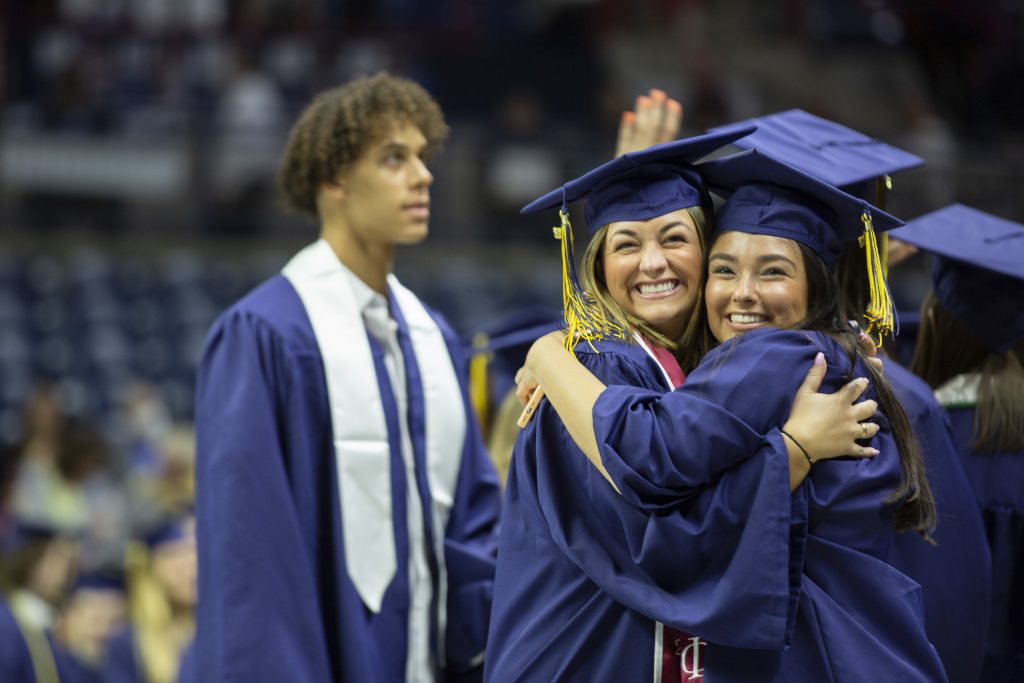 Graduates embrace during commencement