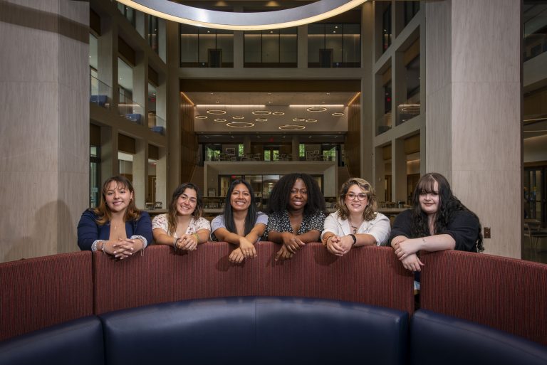 UConn’s Gilman Scholars Samantha Valle ’24 (CLAS), Marissa White ’25 (CAHNR), Geraldine Uribe ’23 (CLAS), Guerlina Philogne ’24 (CLAS) (BUS), Rose Pacik-Nelson ’23 (CLAS), and Grace Coburn ’23 (CLAS) posing in the lobby at UConn Hartford.