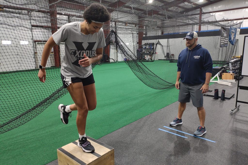 Athletic trainer supervising athlete exercising