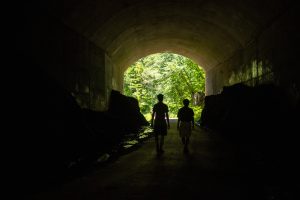 UConn students Robert Avena (left) and Sumeet Kadian (right) walk through the dark Hop River Trail tunnel in Bolton Notch State Park that runs under Interstate 384 in Bolton, CT