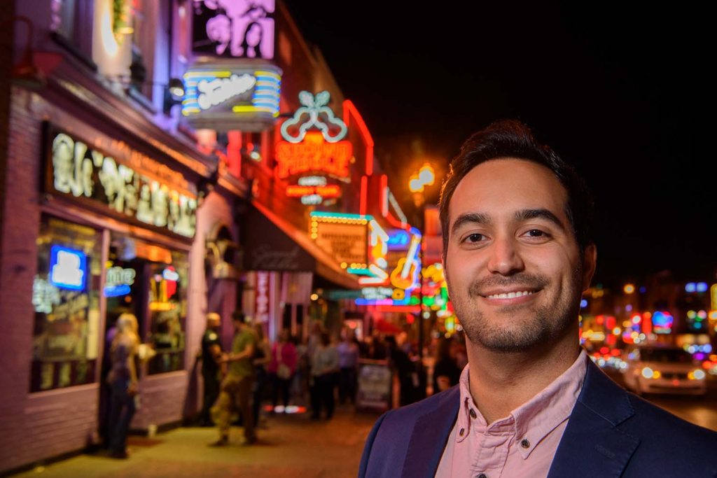 Photo of Ricky Hernandez standing in downtown Nashville at night
