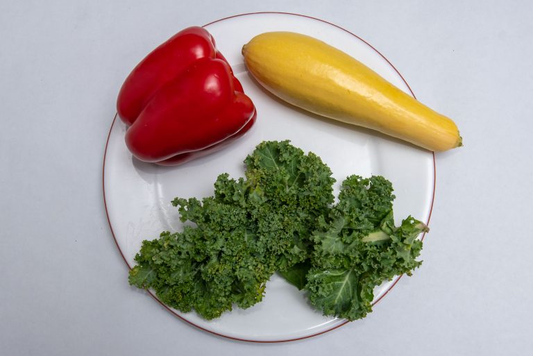 Vegetables including kale, yellow squash, and a red pepper on a plate. (healthy food) Jan. 20, 2021. (Sean Flynn/UConn Photo)