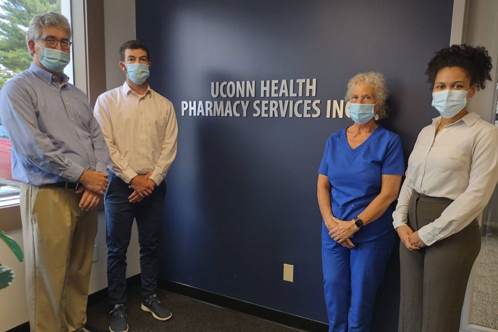 group portrait in front of UConn Health Pharmacy Services Inc. sign