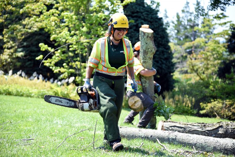 Smiling woman with chainsaw