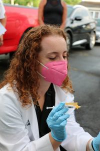 Julia Levin, first-year UConn medical student, prepares to inoculate a patient on the street in Hartford.
