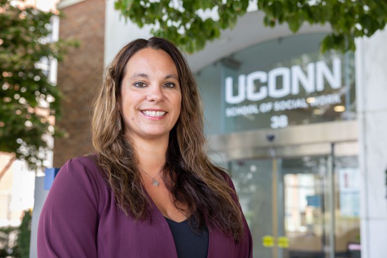 UConn School of Social Work professor Cristina Wilson poses for a photo in front of the School of Social Work Building on the UConn Hartford campus on Sept. 1, 2022.