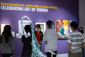 Amanda Douberley (center), assistant curator and academic liaison of the William Benton Museum of Art, shows students around the “Celebrating Art by Women” exhibition on display in the museum