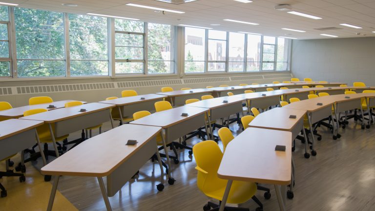 Empty rows of desks in a classroom.