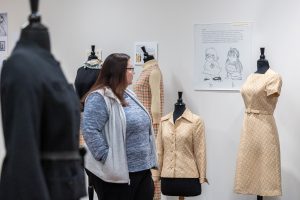 Leann Sanders, an administrative assistant in the Jorgensen Center for the Performing Arts, looks at some of the items on display in the Jorgensen Gallery’s current exhibit celebrating the UConn Women’s Center’s 50th anniversary.