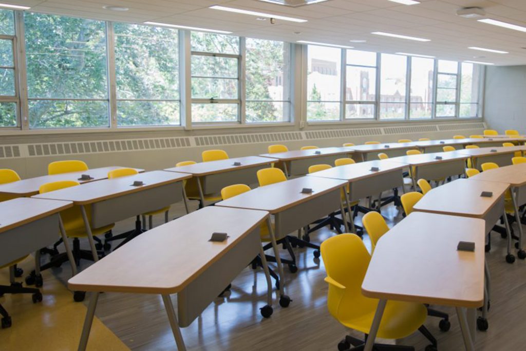 Empty rows of desks in a classroom.
