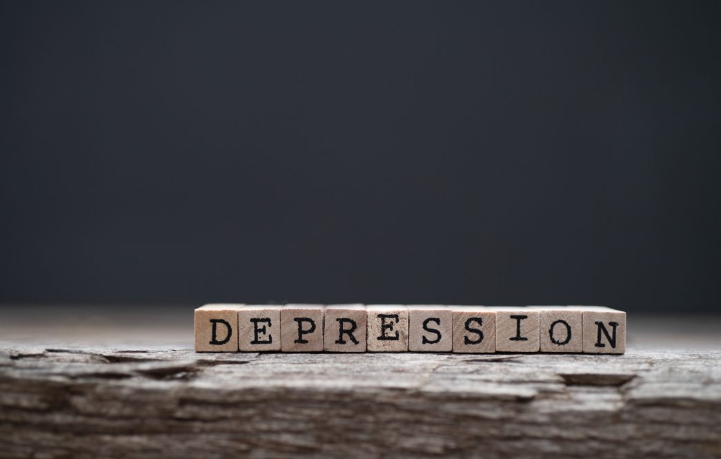 The word depression on a wood background and dark background.
