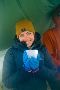 Caroline Wexler ’24 (CLAS) holding a piece of ice on the Juneau Icefield.