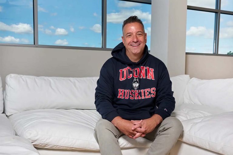 Marc D’Amelio sitting on his couch in his Connecticut home