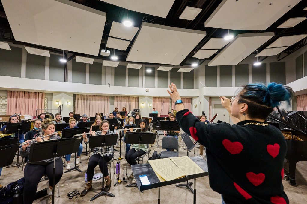 Janet Kim, assistant professor of music, leads a wind ensemble rehearsal