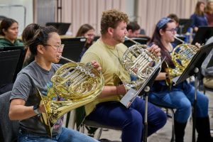Three students play the french horn