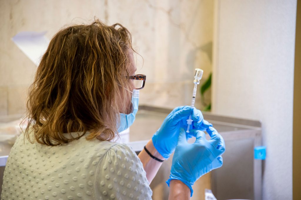 Employee fills syringe