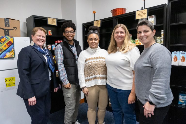 From left, campus director Dr. Jennifer Orlikoff, Husky Harvest student workers Djanne Martinez and Eden Davies, professor Laura Bunyan, and operations worker Rosa Rizzo pose for photo in the “Husky Harvest” food pantry at UConn Stamford