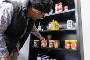 Husky Harvest student worker Djanne Martinez looks through the stock in the “Husky Harvest” food pantry at UConn Stamford