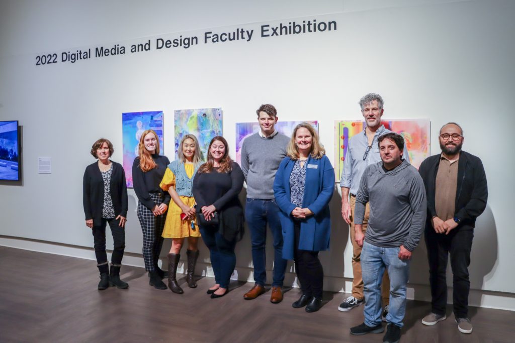 Catherine Masud, Laurel Pehmoeller, Heejoo Kim, Sam Olschan, James Coltrain, Heather Elliott-Famularo, Kerry Smith, Michael Toomey, and Tanju Özdemir pose for a photo during the 2022 Digital Media and Design Faculty Exhibition opening reception at the William Benton Museum of Art