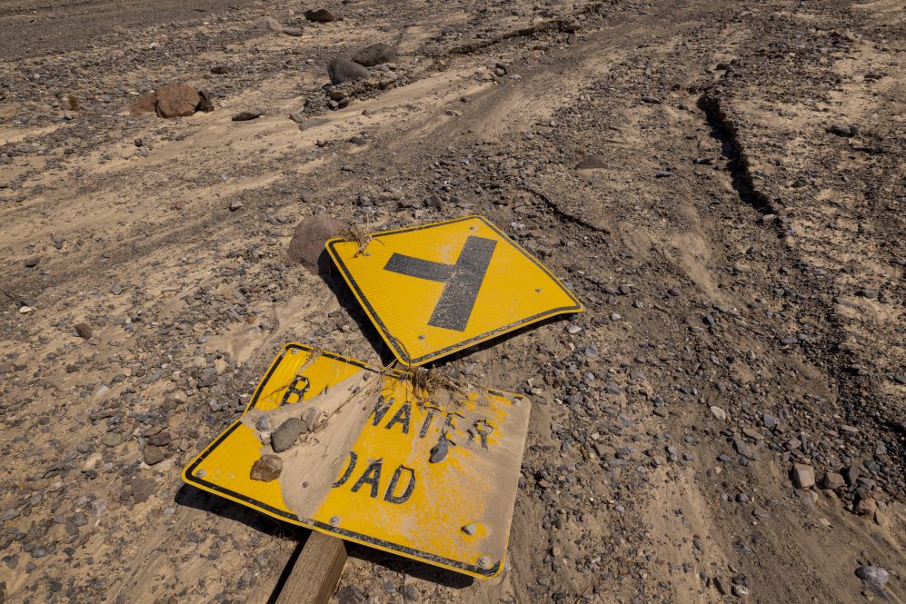 The sign to the Badwater Road turnoff is left in the debris of flood waters downstream from where dozens of cars were damaged as Death Valley National Park partially reopens two weeks after record-setting rainfall caused a historic flash flood, on August 20, 2022 in Death Valley, California. Heavy rainfall from cloudbursts across California's deserts has caused major damage in many areas. Death Valley National Park, Mojave National Preserve and Joshua Tree National Park are still recovering and only partially reopened. Park representatives said that the storm that shut down Death Valley on August 6 was a once in a thousand years event and could be the most widespread catastrophic event in the park's history, damaging 60 vehicles and trapping 1,000 people.