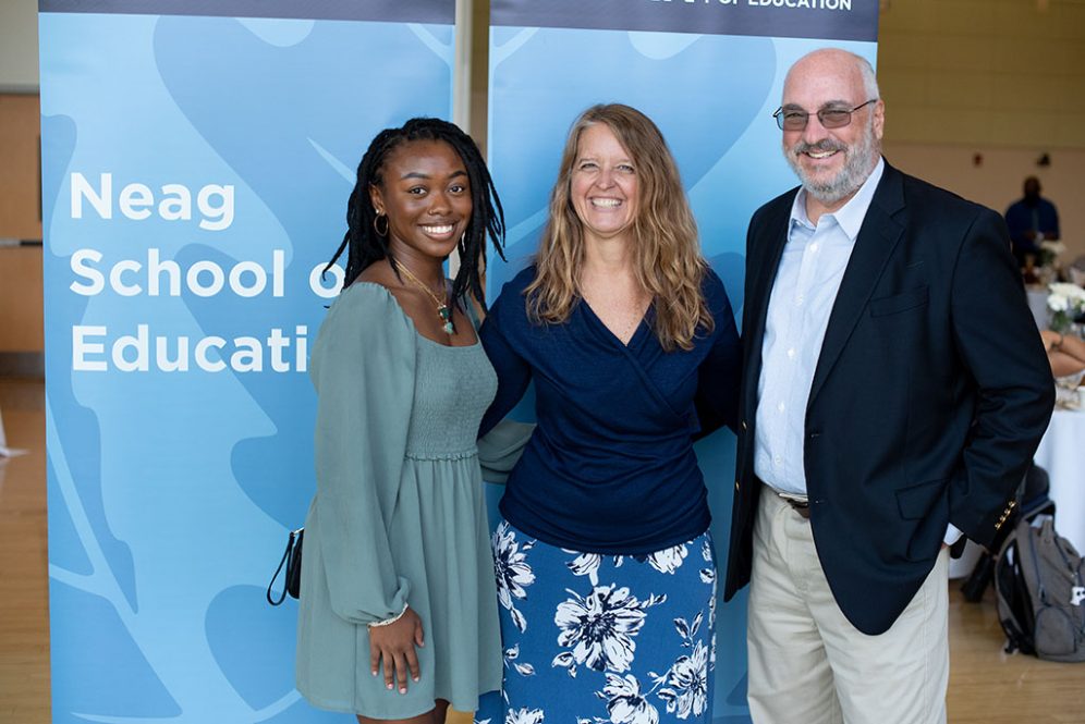 Three people pose for a photo at a scholarship event.