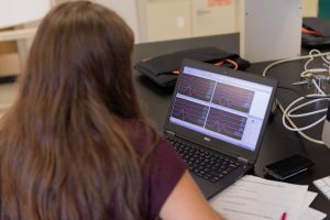 A student looks at sensor readings on a laptop.