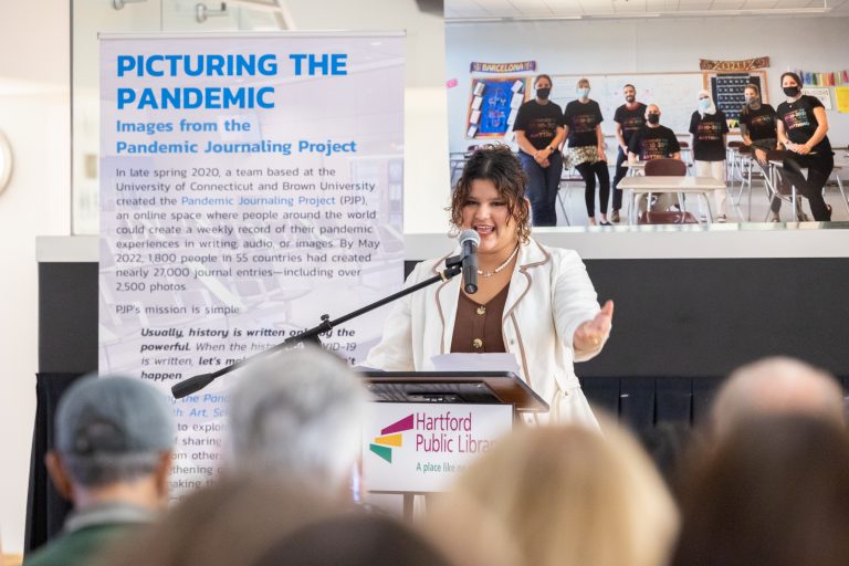 Melinda Das, a tenth grader at Whetherfield High School and one of the contributors to the “Picturing the Pandemic” exhibition, speaks during the opening reception of the exhibition at the Hartford Public Library