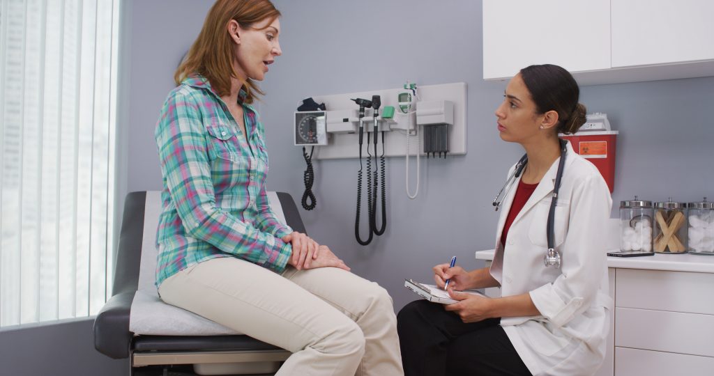 Woman consulting with doctor about future health condition.