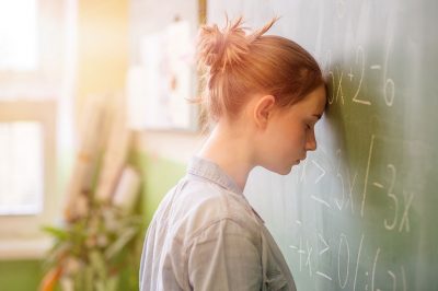 Image of student looking frustrated at a classroom blackboard (ThinkStock photo)