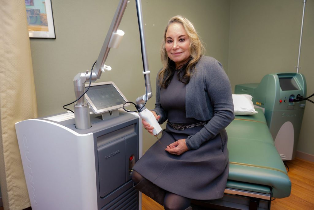 Dr. Maritza Perez with laser machine in dermatology exam room