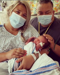 parents holding child in neotnatal intensive care unit