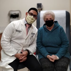 Portrait of Dr. Anthony Diaz and patient in exam room