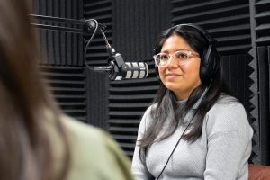 Geraldine Uribe sits in front of a microphone in an audio studio.