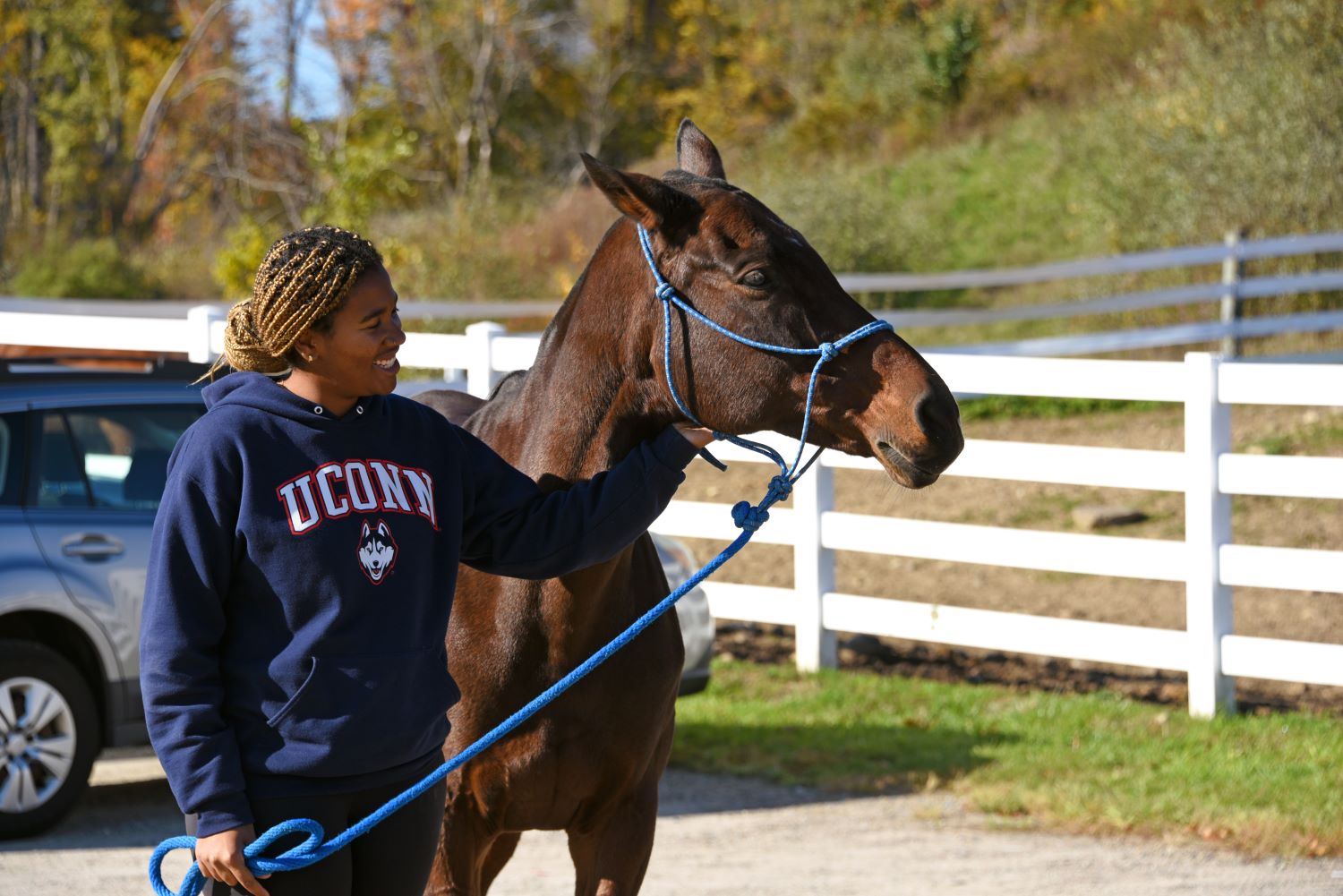 Female student walks with a horse