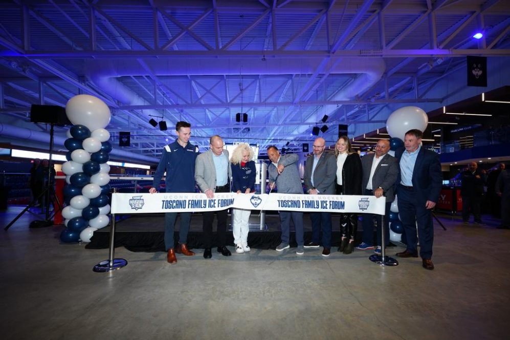Photo of delegates including Dan Toscano, President Maric, and Athletic Director David Benedict cutting the ribbon at the Toscano Family Ice Forum Ribbon Cutting ceremony