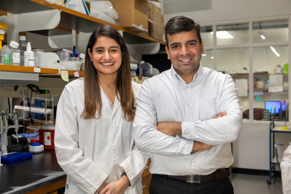 Dr. Shipra Malik, left, and associate professor of pharmaceutics Dr. Raman Bahal pose for a photo in a lab inside the Pharmacy/Biology Building