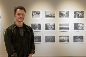Noah Thompson ’24 poses next to “Mr. Teale the Younger and His Pictures,” one of his contributions to the “Raid the Archive: Edwin Way Teale and New Works” exhibition currently on display in the William Benton Museum of Art