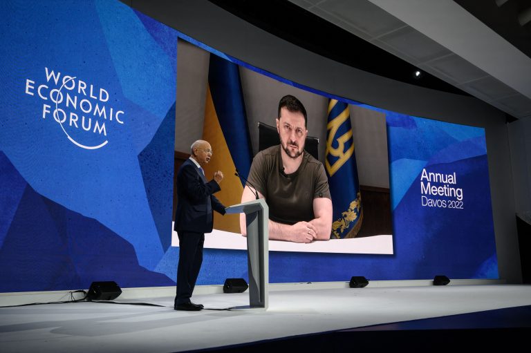 Founder and executive chairman of the World Economic Forum Klaus Schwab welcomes Ukrainian President Volodymyr Zelensky seen on a giant screen by video link at the Congress centre during the World Economic Forum (WEF) annual meeting in Davos on May 23, 2022.