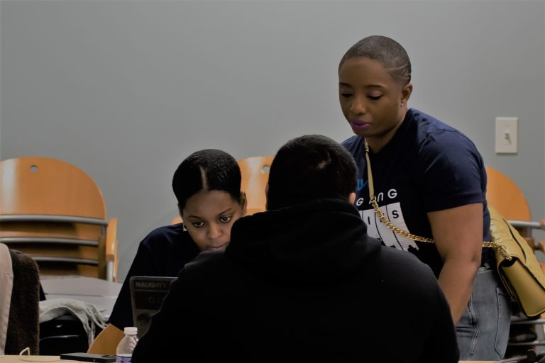 UConn Law student Farah Jean, left, and graduate Tiana Hercules '08, right, work with someone seeking a pardon at the Changing Legacies: Expungement Clinic at Capital Community College on Feb. 25, 2023.
