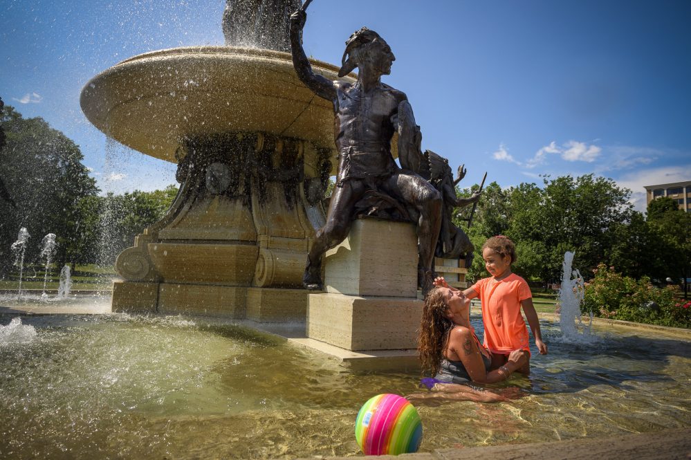 Mildred Rosado, 46, cools off with Faith Marie, 5, granddaughter of her friend Ronald Heath, in the water of Hartford's Corning Fountain