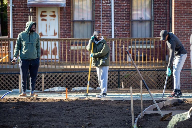 Olusekun (center) and fellow Celtics employees built and installed garden beds at the Winthrop Street Community Garden in Medford, Massachusetts.
