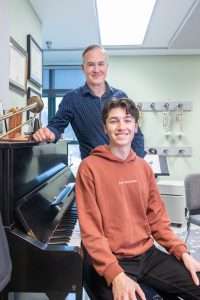 UConn professor of trumpet Louis Hanzlik, back, poses for a photo in his office in the Music Building with his son Ethan Hanzlik