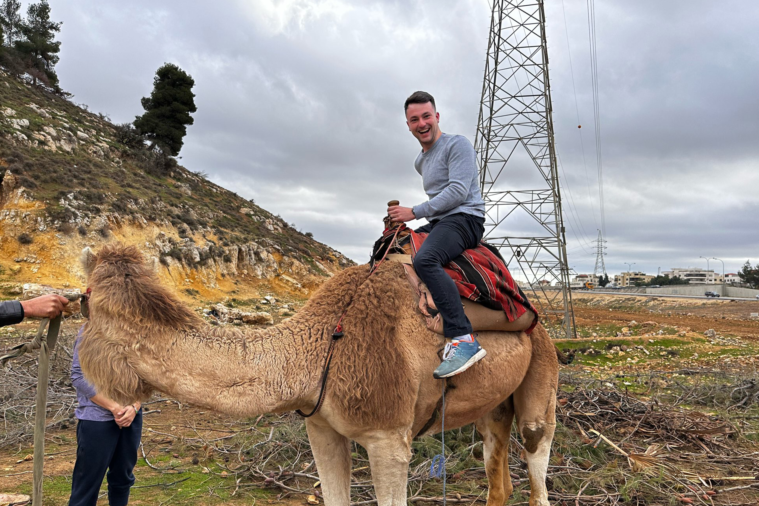 Goggins sits on a camel on a roadside in Jordan.