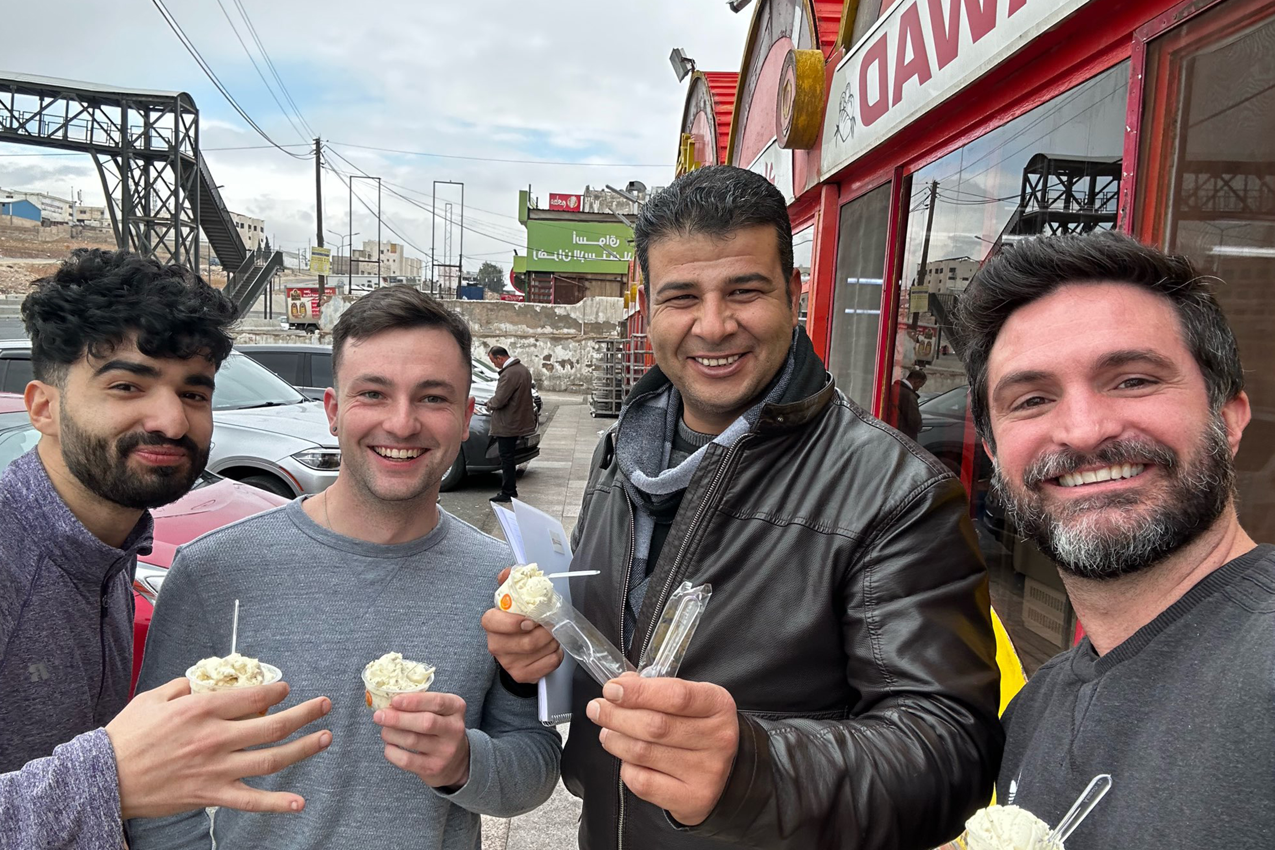 Massyl Mallem ’23 (ENG), Peter Goggins, Shlash al-Oun, and David Coles eating a Middle Eastern gelato-like dessert in Jordan.