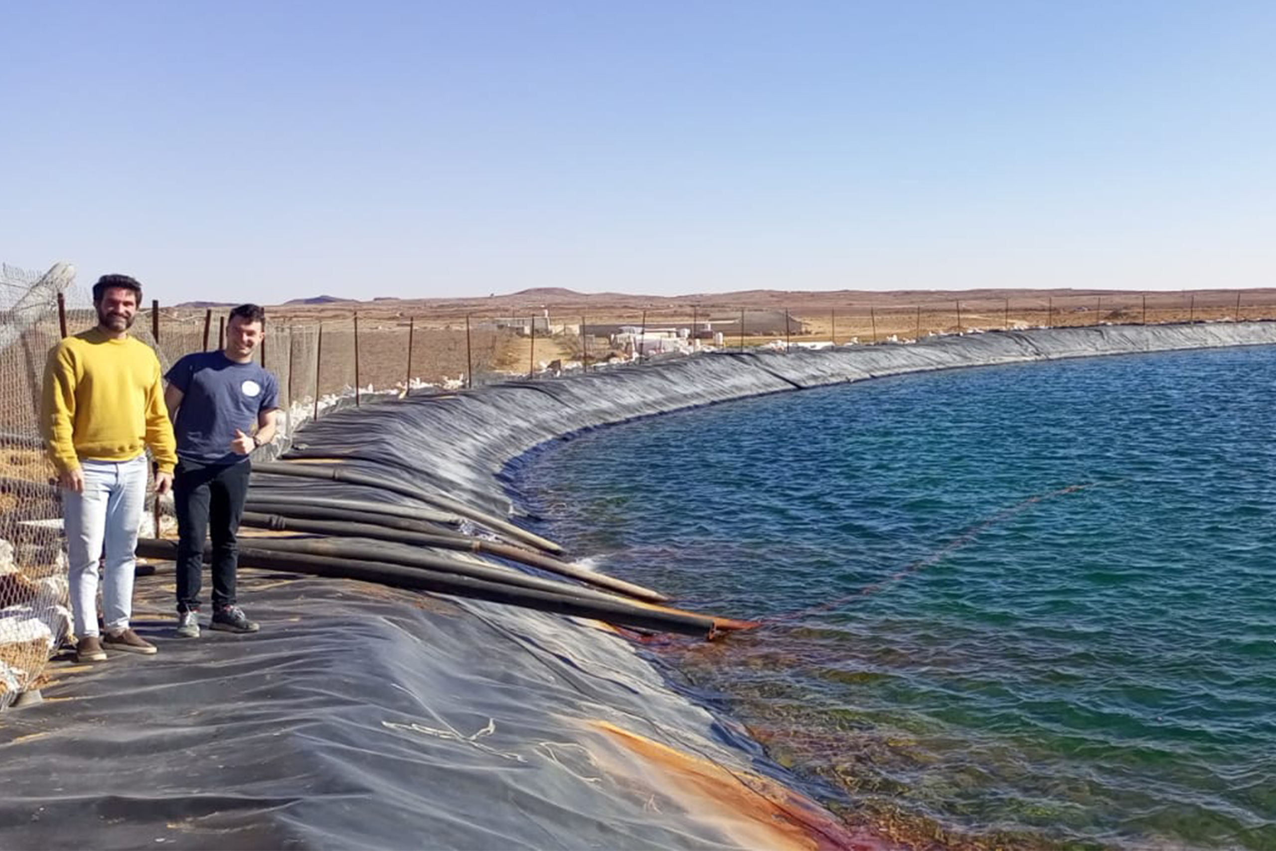 Goggins and David Coles at an irrigation holding pond on al-Oun’s farm in Jordan – the family plans to begin using the pond to grow fish as well, as many other farmers in the region are also now doing.