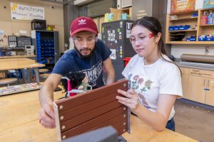 UConn mechanical engineering students Eddy Ramos, left, and Kaley Luk work on the prototype of their project for Senior Design Demonstration Day—an affordable, ADA-compliant, sustainably produced, easy-to-assemble accessibility ramp—in the Innovation Zone in the Peter J. Werth Residence Tower