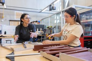 UConn mechanical engineering students Leila Awad, left, and Kaley Luk work on the prototype of their project for Senior Design Demonstration Day—an affordable, ADA-compliant, sustainably produced, easy-to-assemble accessibility ramp—in the Innovation Zone in the Peter J. Werth Residence Tower
