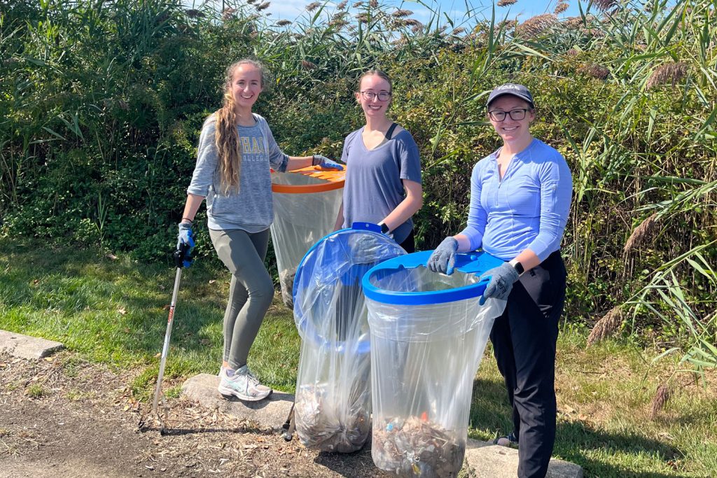 three women picking up trash