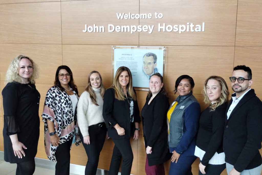 Group portrait in front of John Dempsey sign