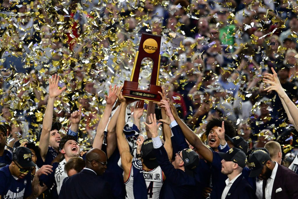 UConn Men's Basketball team hoisting the NCAA trophy